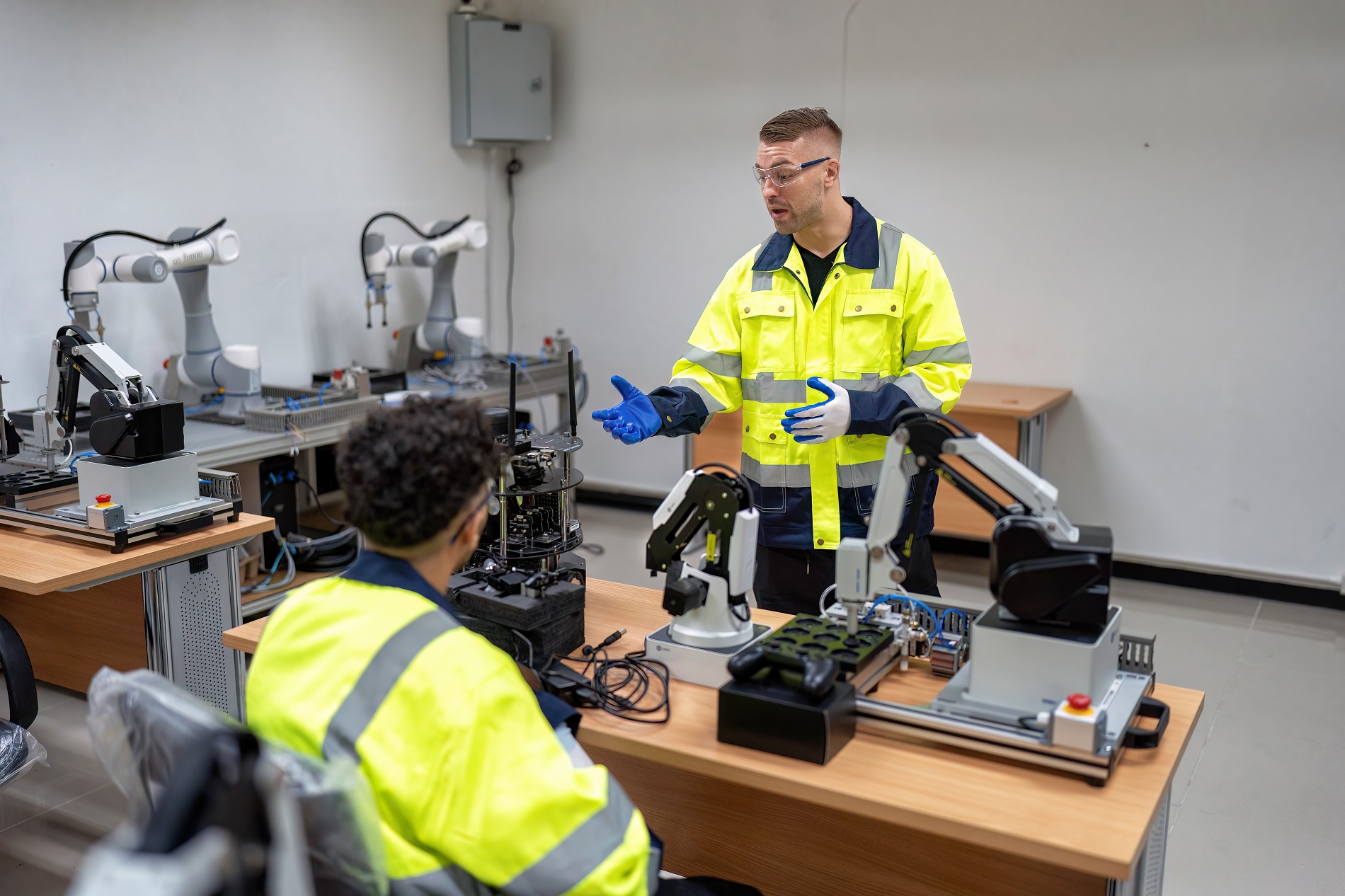 Engineer teach trainee how to operation maintenance and programing robot arm in training room