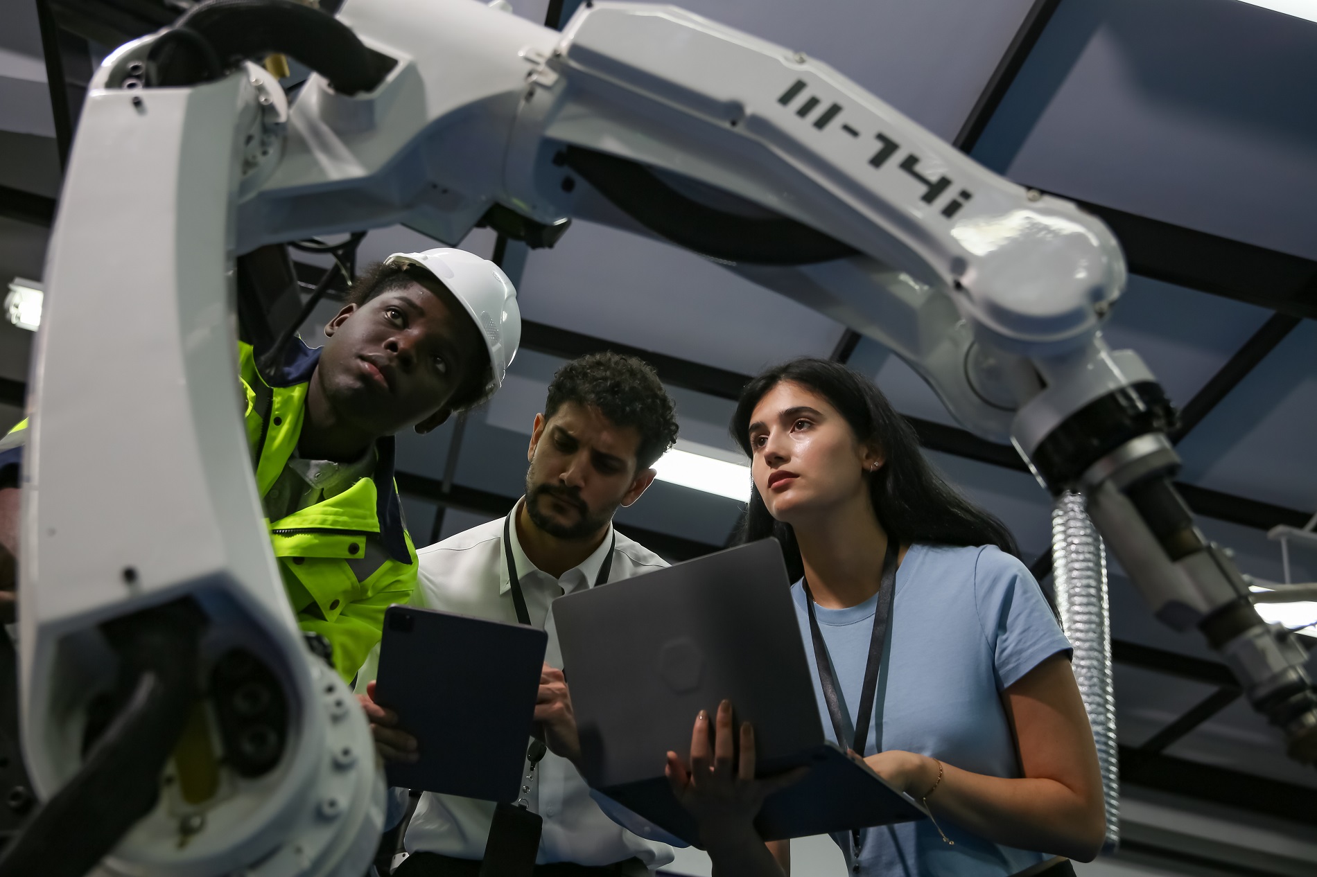 Engineers inspecting and check up machine of the automated arms machine robots at factory. Engineer working automatic robotic arm machine in factory. technician worker maintenance robot. Technology concept.