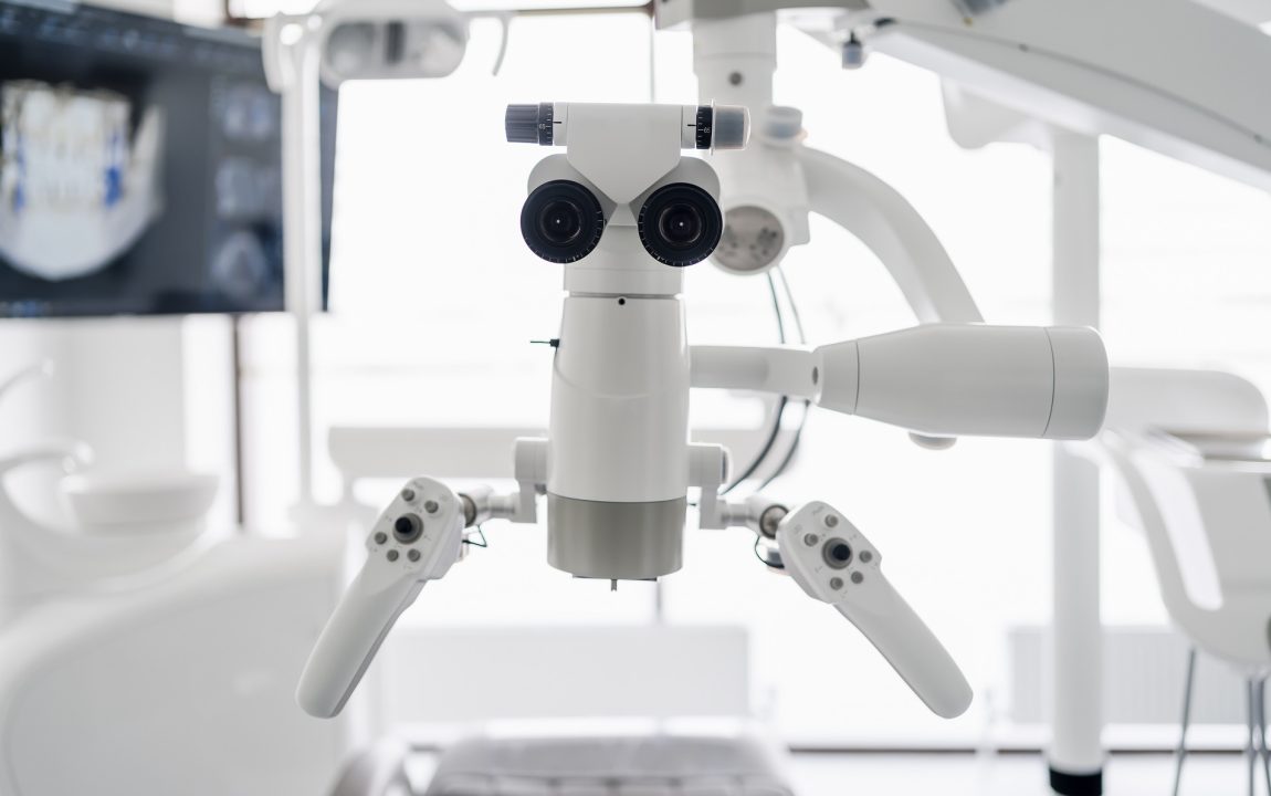 Interior of dental practice room with close up on microscope and dental scan on the display. Stomatology modern equipment